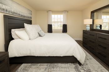 A bedroom with a large bed, a dresser, and a mirror at Chapel Valley Townhomes, Nottingham, 21236